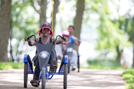 Woman rides Wheel Fun Rentals bike around a park.