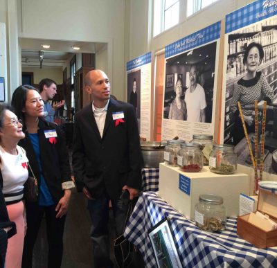 Ms. Hunh and family look at her spot in the Eat Street at 20 exhibit at the Hennepin History Museum.