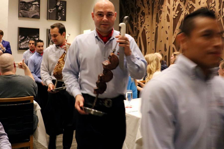 Server at Fogo de Chao carrying meat at preview day