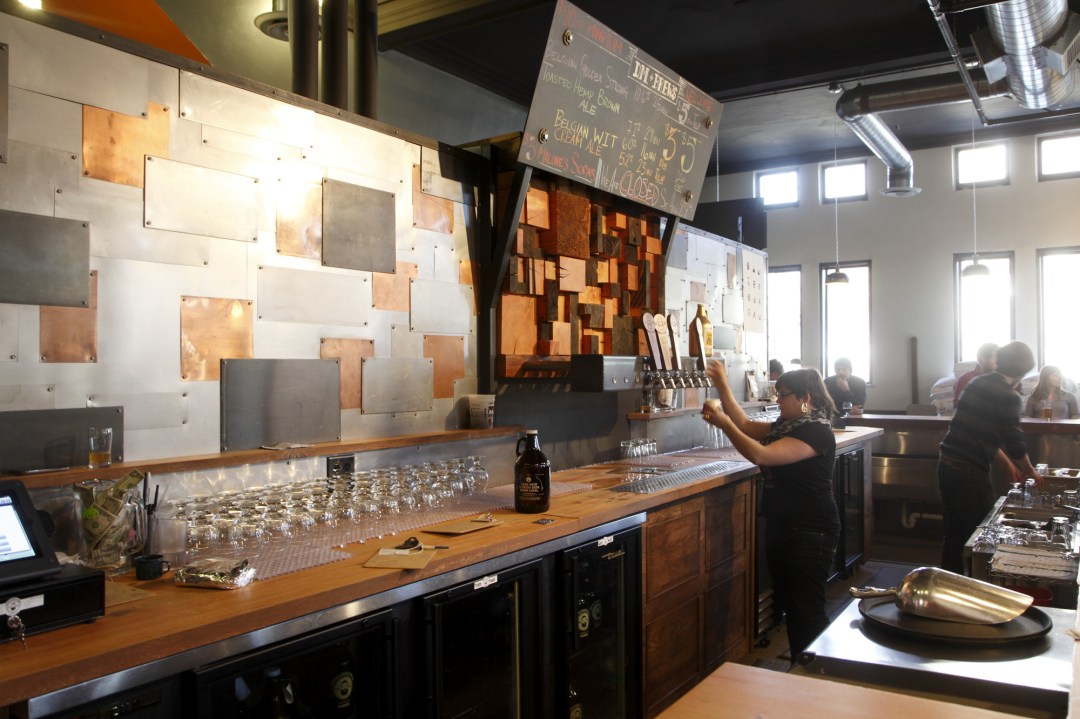 Bartender pouring a pint of Dangerous Man beer at the brewery