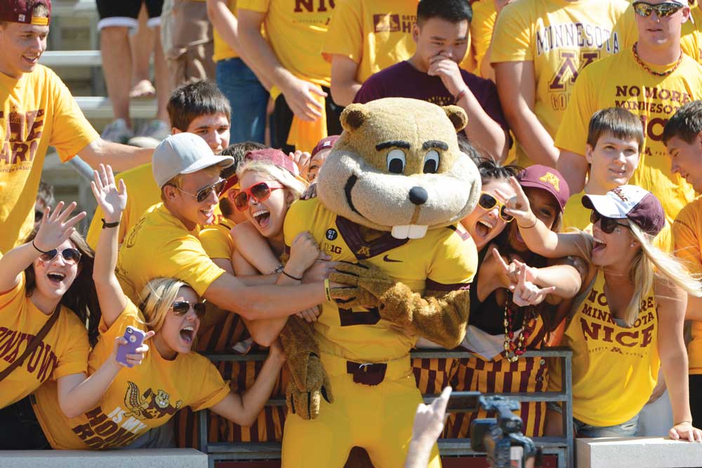 Students posing for a photo with Goldy Gopher at a University of Minnesota football game. Just one of the many stops along the Metro Transit Green Line.