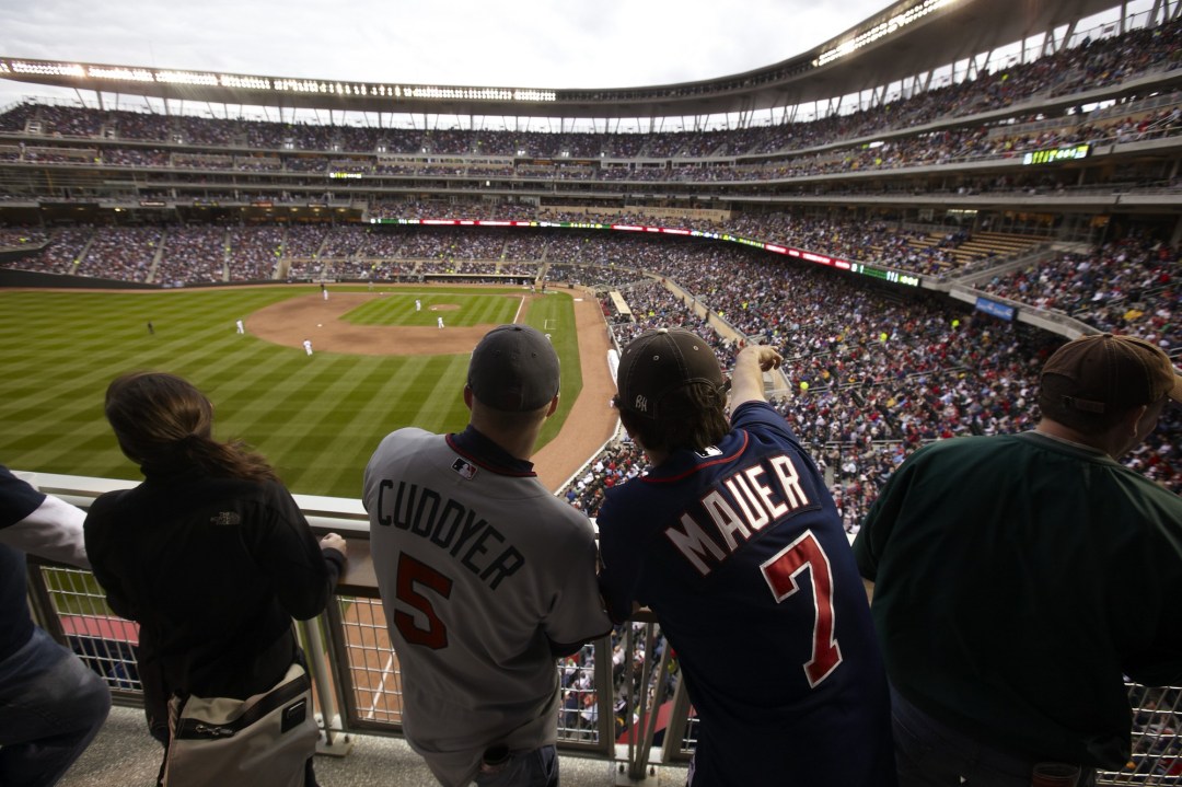 Two MN Twin fans watching a baseball game on the third base line